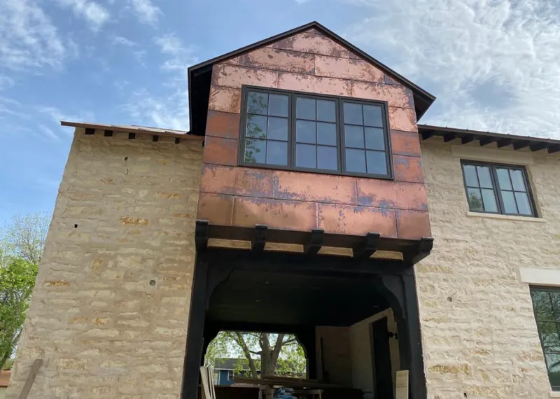 Copper metal panel facade on a stone building for Skylight Installation in Weston